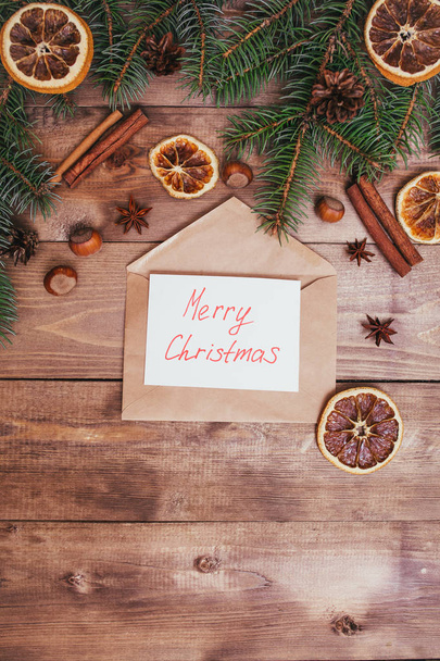 Merry Christmas text with food decorations on brown wooden background - Φωτογραφία, εικόνα