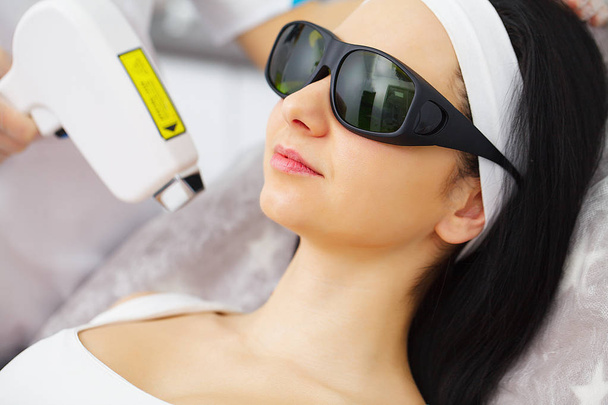 Cosmetology. Ultrasonic face cleaning, peeling, in a beauty salon. Beautiful Woman Receiving Facial Skin Ultrasound Cavitation. - Fotó, kép