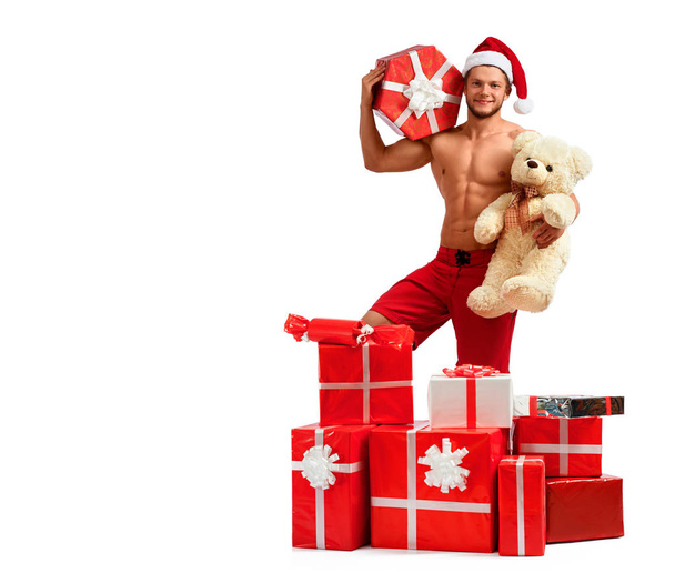 Handsome Santa Claus standing in a pile of presents - Foto, imagen