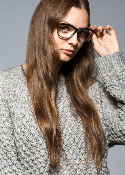 moda ragazza su uno sfondo grigio in studio in posa con ascar
 - Foto, immagini