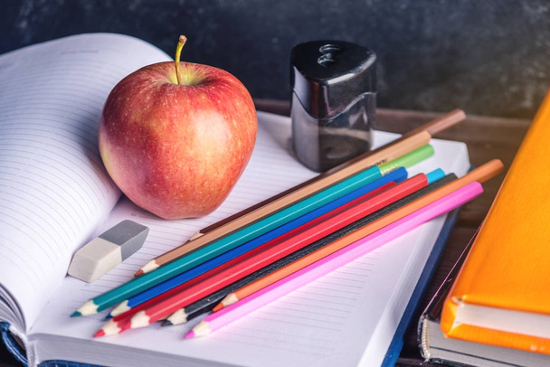 Material escolar na mesa. Livros, lápis e maçãs é uma coleção do estudante. Conceito de escola e educação
 - Foto, Imagem