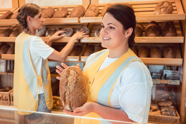 Две продавщицы, продающие хлеб и другие продукты в пекарне
 - Фото, изображение