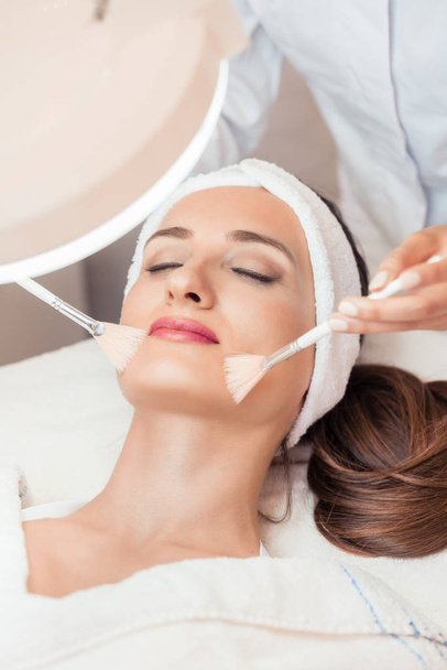 Beautiful woman during anti-aging facial massage in a modern cos - Photo, image