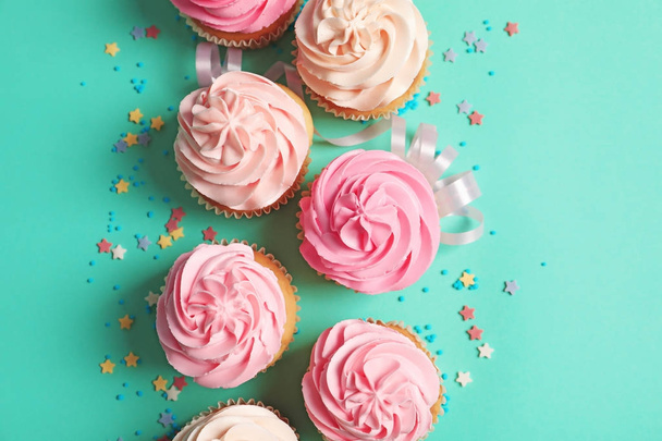 Many yummy cupcakes on color background - Foto, afbeelding