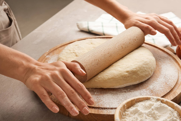 Female chef rolling dough - 写真・画像
