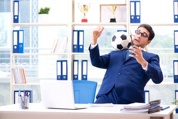Businessman playing football in the office - Zdjęcie, obraz