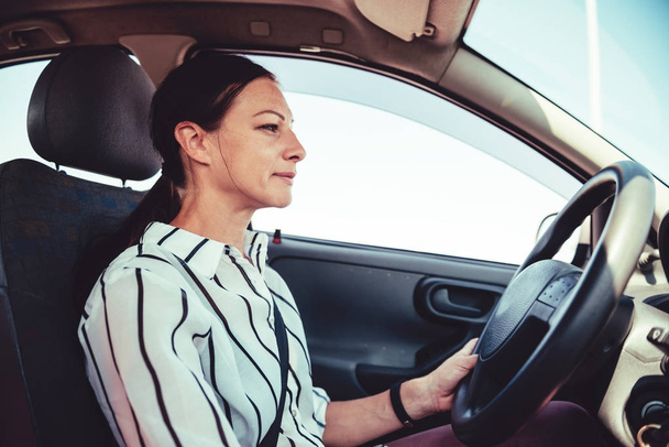 Woman driving car during the day and enjoying  - Photo, image