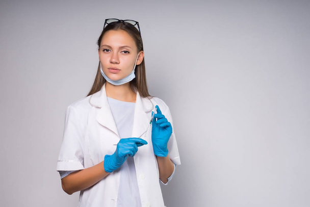 girl in a white robe and gloves angrily looks at the camera, isolated - Foto, Imagem