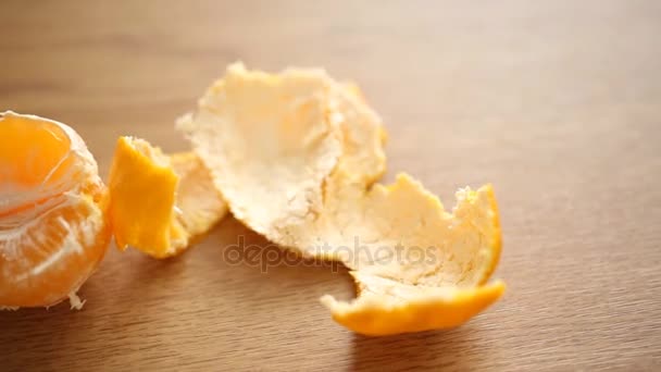 Половина мандарина с кожурой на столе
  - Кадры, видео