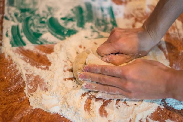 Female hands knead the dough for cooking. - Φωτογραφία, εικόνα