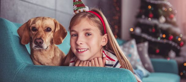 Little girl with dog posing on sofa - Fotoğraf, Görsel