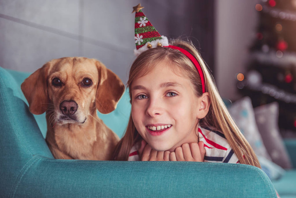 Little girl with dog posing on sofa - 写真・画像