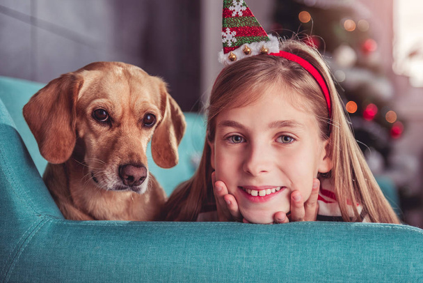 Little girl with dog posing on sofa - Foto, Imagen