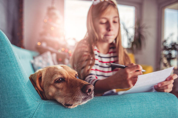 Girl with dog writing wish list  - Фото, зображення