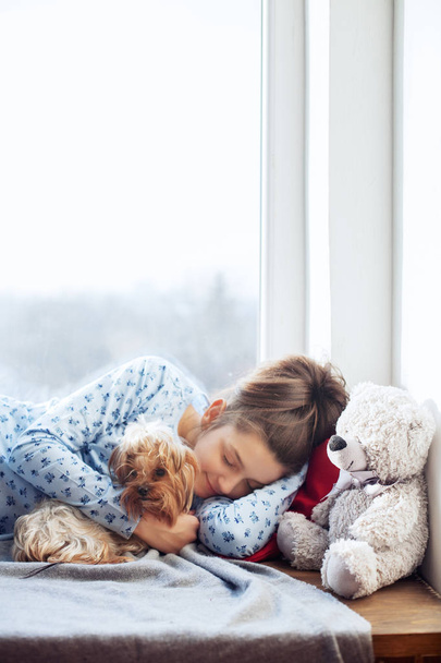 Chica feliz durmiendo en los alféizares. El concepto de Navidad
. - Foto, imagen