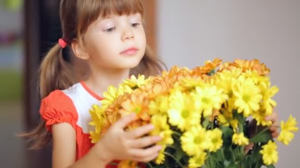 Small girl embraces bunch of yellow flowers - Video