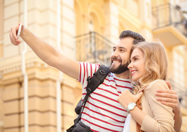 Couple of young tourists taking selfie on the street - Foto, Imagen