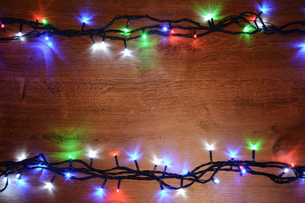 木製の背景のクリスマス電気花飾り。明るい電球 o - 写真・画像