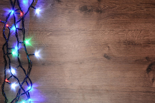 Elektrischer Neujahrskranz auf einem hölzernen Hintergrund. helle Lampen o - Foto, Bild