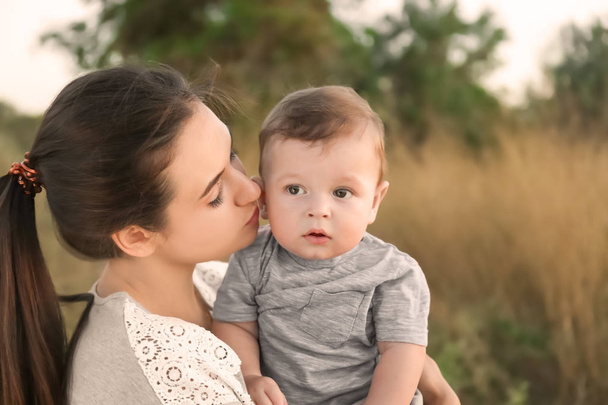 Güzel genç anne holding şirin bebek çocuk, açık havada - Fotoğraf, Görsel