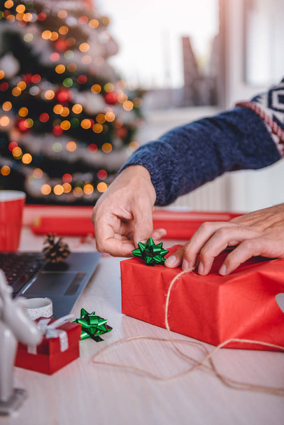 Man wrapping Christmas gift - Fotó, kép