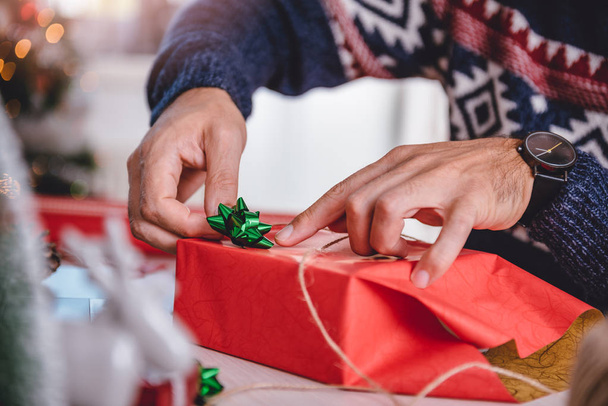 Man wrapping Christmas gift - Foto, Imagen