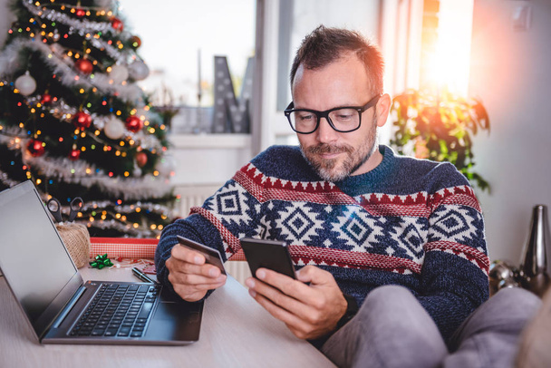мужчина делает покупки в Интернете на Рождество
 - Фото, изображение