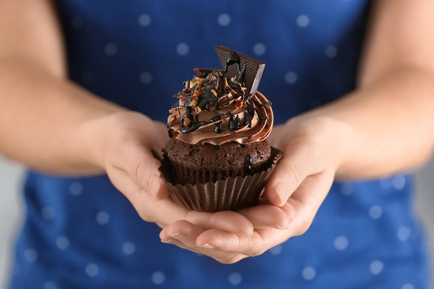Woman holding tasty chocolate cupcake - Photo, image