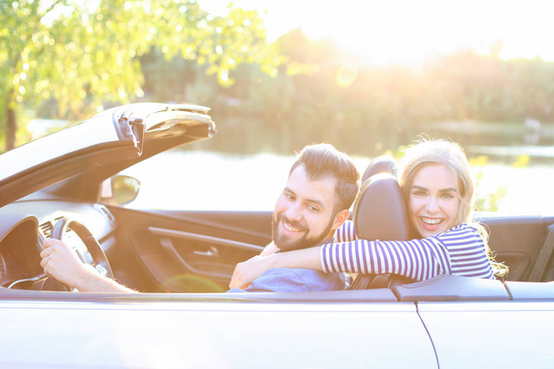Happy young couple in car on road trip - Foto, imagen