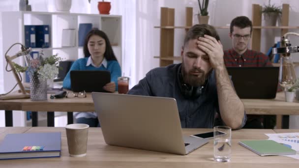 Freelancer cansado sonolento a bisbilhotar na secretária no escritório
 - Filmagem, Vídeo
