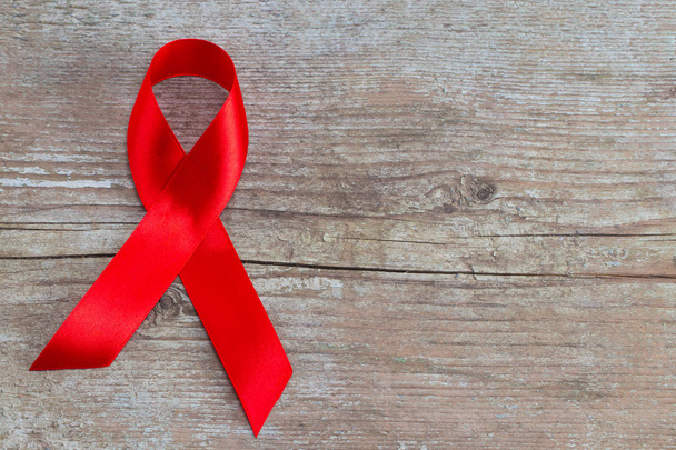 Piros szalag - Aids tudatosság szimbólum a fából készült háttér - Fotó, kép