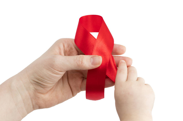 Aids fita vermelha no apoio das mãos da mulher e da criança para o mundo a
 - Foto, Imagem