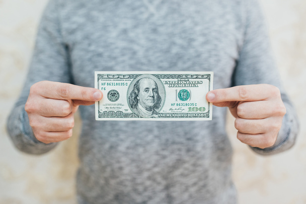 Ένας άνθρωπος με δολάρια στα χέρια της. Απομονωμένα σε λευκό φόντο - Φωτογραφία, εικόνα