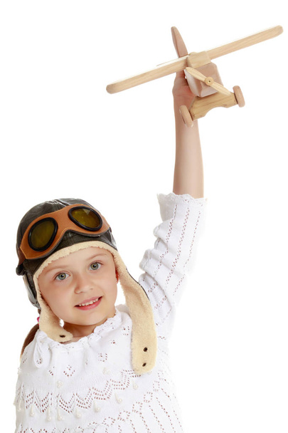 Petite fille avec un avion en bois à la main. - Photo, image
