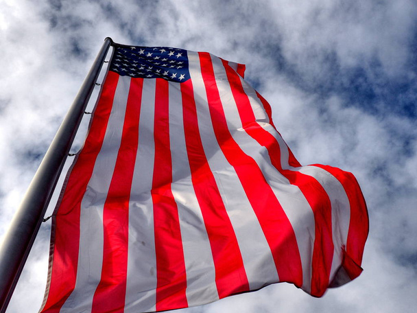 曇り空を背景に旗を振ってアメリカ合衆国 - 写真・画像