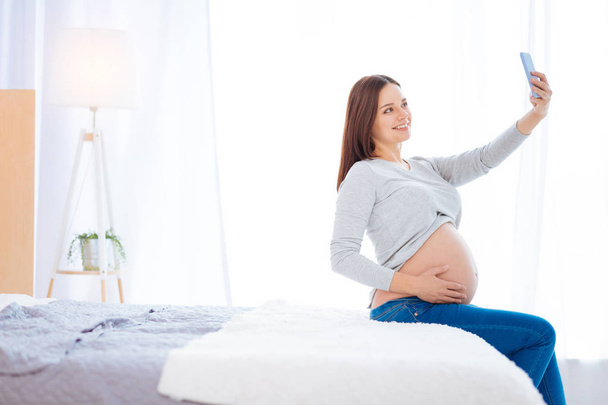 Cheerful pregnant woman taking selfie - Zdjęcie, obraz