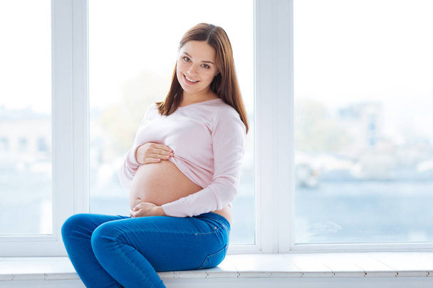 Elegant pregnant woman smiling at the camera - Foto, imagen