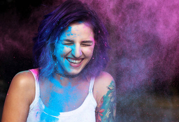 Donna emotiva con i capelli viola divertirsi con polvere secca di Holi
 - Foto, immagini