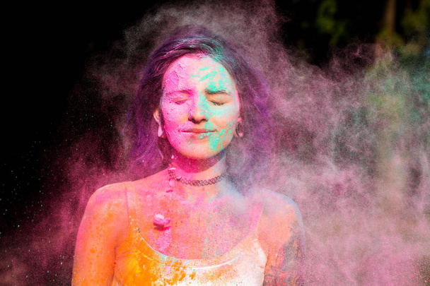 Bella donna in posa con esplodere rosa e verde polvere di Holi a
 - Foto, immagini