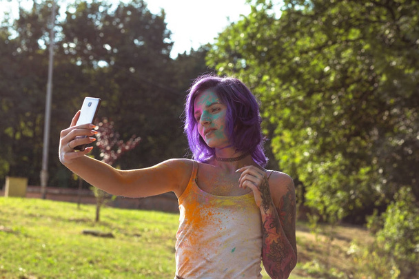 Beautiful tattooed woman with purple hair taking selfie at the H - Photo, Image