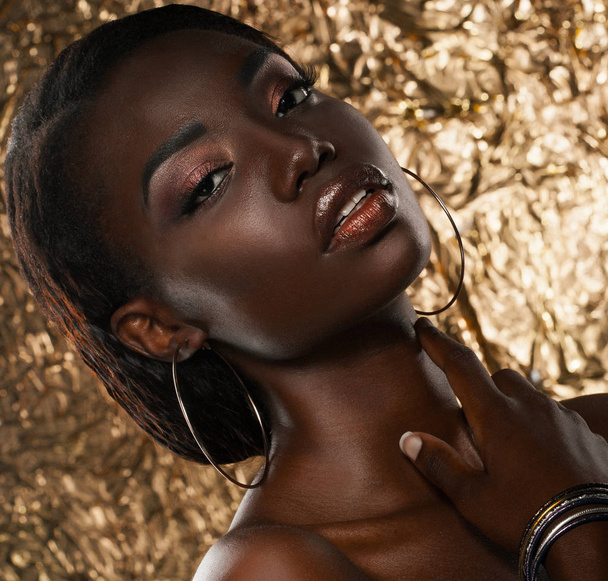 portrait of sensual young african woman against golden background - Foto, imagen