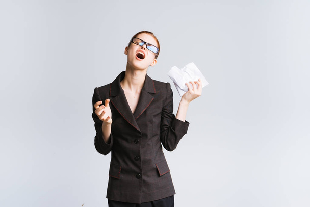 a girl in a black, strict suit and wearing glasses is tired of work and screams, isolated - Foto, imagen