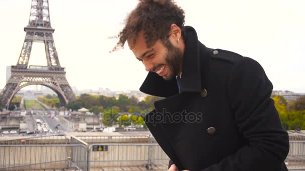 Mulatte lacht mit Smartphone in Zeitlupe um den Eiffelturm. - Filmmaterial, Video