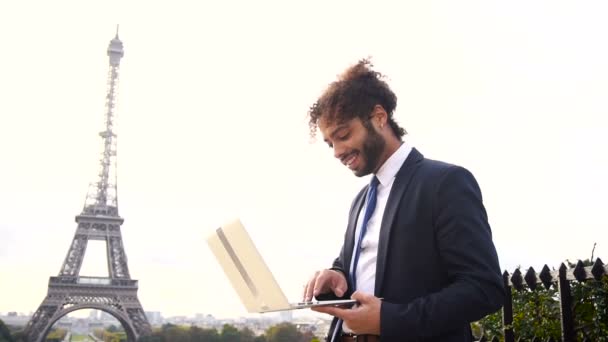 Reisemanager mit Laptop mit Eiffelturm im Hintergrund in Zeitlupe. - Filmmaterial, Video