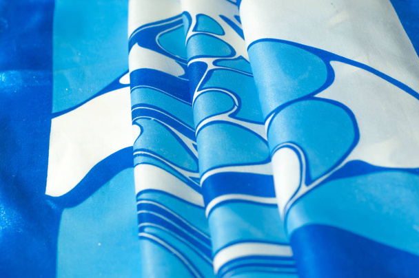 Texture, sfondo, pattern. Un fazzoletto di seta da donna. Scialle modello astratto, modelli blu su sfondo bianco
 - Foto, immagini
