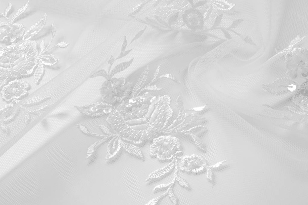 Textur Tüll ist weiß wächst in einem kühnen floralen Design verpassen Sie nicht die Chance, dieses Weiß auf weißem, blumig besticktem Tüll kaufen große Blumenvignetten wachsen Säulen über einem sauberen weichen Tüll - Foto, Bild