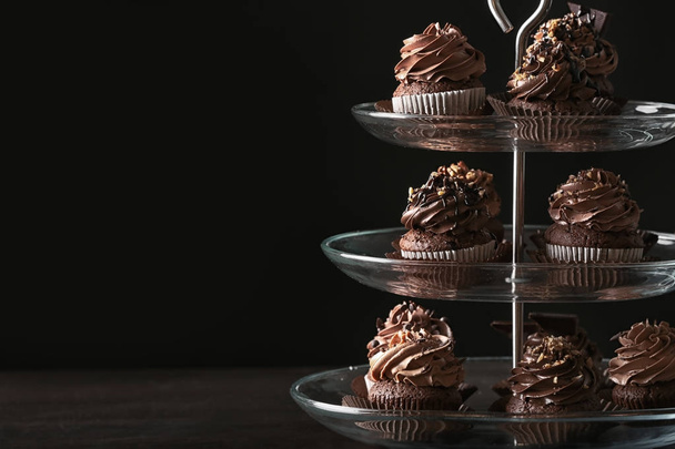 Dessert stand with tasty chocolate cupcakes - 写真・画像
