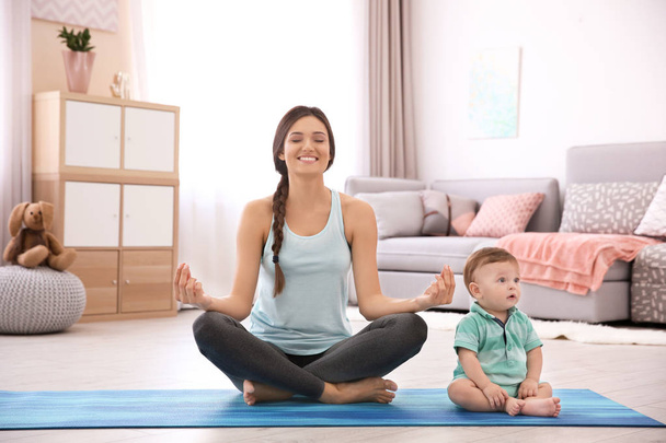 Young mother doing yoga with baby at home - Foto, Imagem