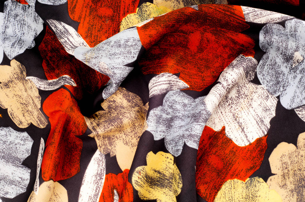 Textura, fondo, patrón. El pañuelo de seda de una mujer está decorado con colores brillantes. Flores rojas amarillas blancas sobre fondo negro
 - Foto, imagen