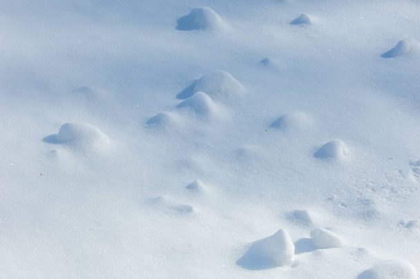 Textuur, achtergrond, patroon. Voetstappen in de sneeuw. De vorst is erg koud. De deken van de witte sneeuw op de grond. Atmosferische waterdamp bevriest in ijskristallen en valt in lichte witte vlokken  - Foto, afbeelding